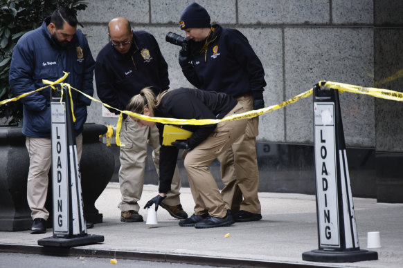 Police investigate the scene of the shooting outside the Hilton in Midtown Manhattan.
