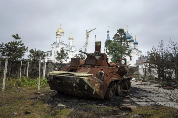 A destroyed Russian APC stands in the yard of a privet house in front of a church in the recently liberated town of Sviatohirsk, Ukraine, Sunday, October 2, 2022.
