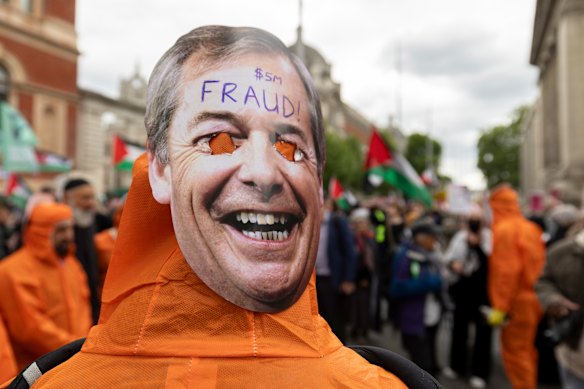 Uma pessoa com uma máscara facial de Nigel Farage durante o protesto Rally Contra o Racismo em Londres no sábado.
