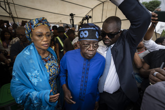 Presidential candidate Bola Tinubu of the All Progressives Congress (centre), accompanied by his wife, Oluremi Tinubu (left) leaves after casting his vote in Lagos.