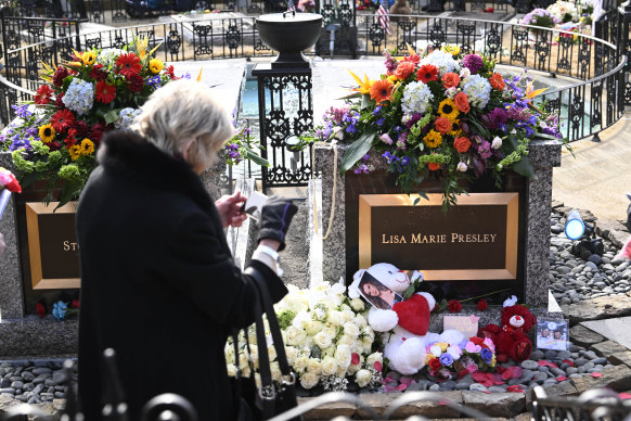 A visitor takes a photo of the gravesite after a memorial service for Lisa Marie Presley.