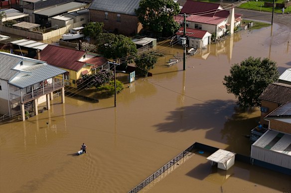 A man dragging an esky through flooded streets in Macksville.