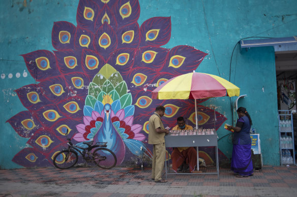 A lottery ticket vendor and some customers in Kochi, Kerala state, India.
