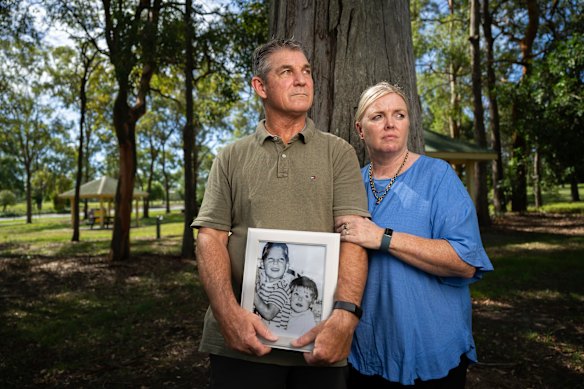 Paul and Linda Grimmer pose for photos with a framed photograph of Paul and his younger sister Cheryl in the 1970s.