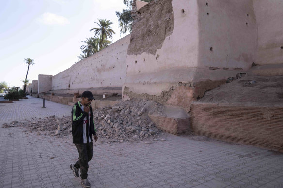 Un uomo cammina vicino a un muro danneggiato nella storica città di Marrakech, dopo il terremoto.