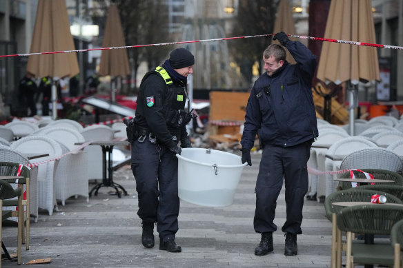 Police officers carry a plastic tub with rescued fish.