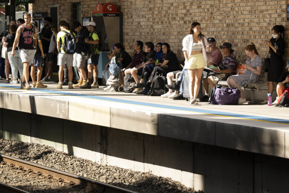 Passengers wait in the heat at Meadowbank Station, after a network communication issue halts all trains in Sydney.