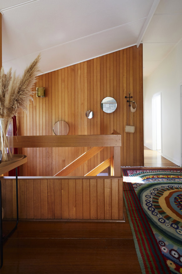 An original timber-panelled wall and staircase lead from the home’s entrance to a self-contained living space. The vintage Swedish rug is from Halcyon Lake.
