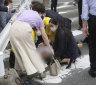 Shinzo Abe falls to the ground.