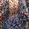 Revellers run with bulls along Calle Estafeta during the San Fermin Running of the Bulls’ festival in Pamplona, Spain. During the Festival of San Fermín, each morning crowds of people race with six bulls and six steers along a winding course through narrow streets to the city’s bullring. Later the same evening, the animals are killed in an evening bullfight or ‘corrida’ in a tradition dating back to medieval times.