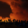 Onlookers watch the volcanic activity in Iceland from a distance on Saturday night.