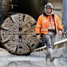 A construction worker walks in front of a tunnel boring machine at Parramatta.