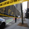 A New York police officer stands on 54th Street outside the Hilton Hotel in midtown Manhattan where Brian Thompson, the CEO of UnitedHealthcare, was fatally shot.