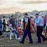 Dr James Otton (centre in blue shirt) assists the wounded at Bondi Beach on Sunday in the aftermath of the attack.