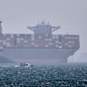 A container ship sits at anchor as a small motorboat passes in the foreground in the Strait of Hormuz on Saturday.