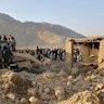 Local residents and civil defence workers look on as a bulldozer clears the rubble of a house hit by a cross-border Pakistani army strike in the Behsud district of Nangarhar province, Afghanistan, on February 22.
