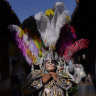 A dancer adjusts his costume before taking part in a procession honoring St. Thomas, the patron saint of Chichicastenango in Guatemala.
