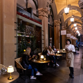The outdoor portico is fringed with cocktail tables.