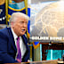 Donald Trump in the Oval Office with an artist’s rendition of his missile-defence “golden dome”.