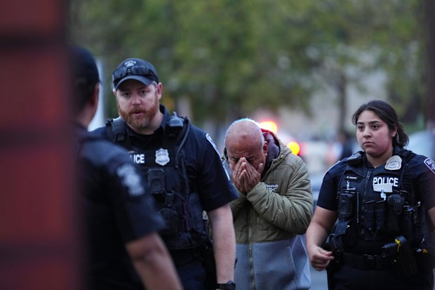 An man is led into the scene by police after they responded to a shooting at Seattle Center.