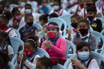戴著口罩和盾牌的學生參加在古巴哈瓦那舉行的集會。