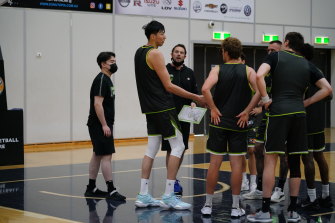 South East Melbourne Phoenix centre Zhou Qi gets to know assistant coach Luke Kendall and his teammates on Wednesday.