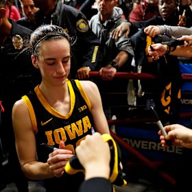 Caitlin Clark signs autographs.
