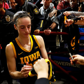 Caitlin Clark signs autographs.