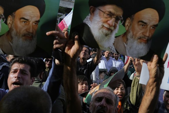 Iranian protesters hold up posters showing the Supreme Leader, Ayatollah Ali Khamenei (centre) and the late revolutionary founder Ayatollah Khomeini after US attacks on Iranian nuclear sites.