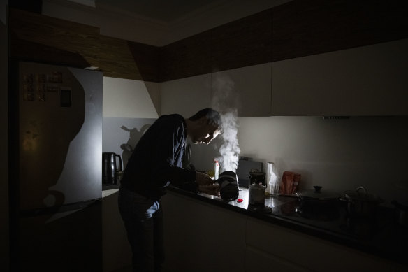 IT worker Igor makes tea using a camping stove in his apartment block in near total darkness during a scheduled power cut.
