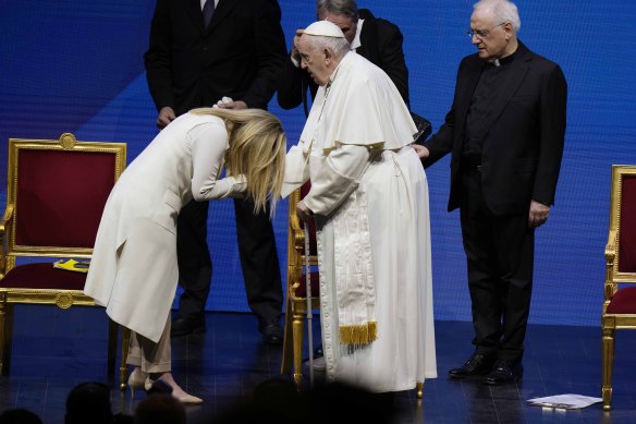 Italian Prime Minister Giorgia Meloni kisses the hand of Pope Francis.