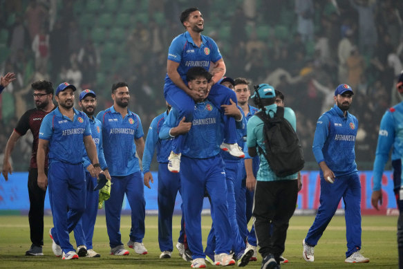 Afghanistan’s Azmatullah Omarzai, center on shoulder, and teammates celebrate after winning the ICC Champions Trophy cricket match against England, in Lahore, Pakistan.