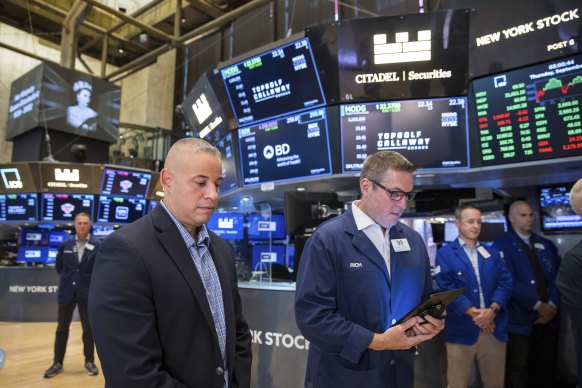 Brokers stand on the floor of the New York Stock Exchange during a moment of silence on Thursday.
