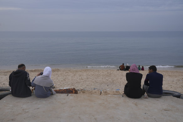 Displaced Palestinians take a break on the beach in  Deir al Balah, Gaza Strip, on Saturday, during the temporary ceasefire between Israel and Hamas.