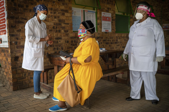 Asnath Masango, right, and Carol Ditshego, left, brief a patient before giving her a COVID-19 test at the Ndlovu clinic in Elandsdoorn, as part of the Johnson & Johnson vaccination trial. 