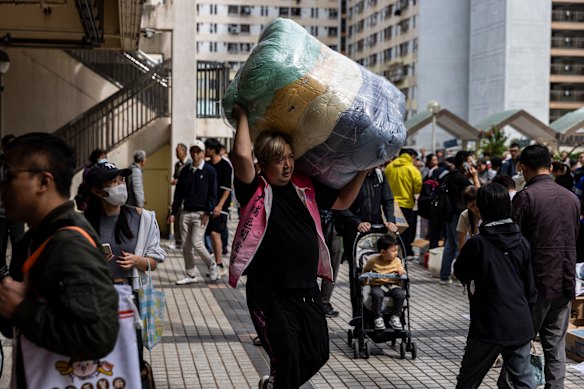 A man carries bedding for those displaced by the Hong Kong fire.