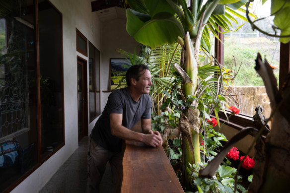 Dave Tsakalakis and his resident water dragon in the Earthship that he helped his mother Candy Disch build in the Narara Ecovillage on the Central Coast of NSW. 