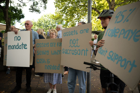 More than 100 protesters gathered outside the council chambers, bearing signs with the slogans “no mandate” and “assets are not sacrosanct”. 