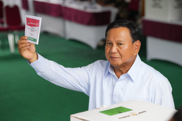 Indonesian presidential candidate Prabowo Subianto shows a ballot during the election in Bojong Koneng, Indonesia.