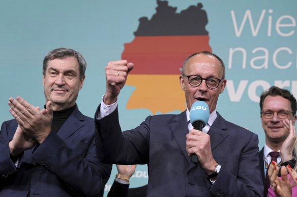 CDU leader Friedrich Merz (front right) gestures while addressing supporters at the party headquarters in Berlin.