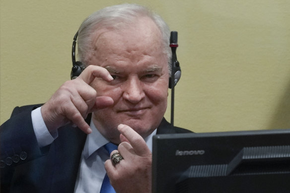 Former military chief Ratko Mladic mimics photographers taking pictures as he waits to hear the result of his appeal on Tuesday.