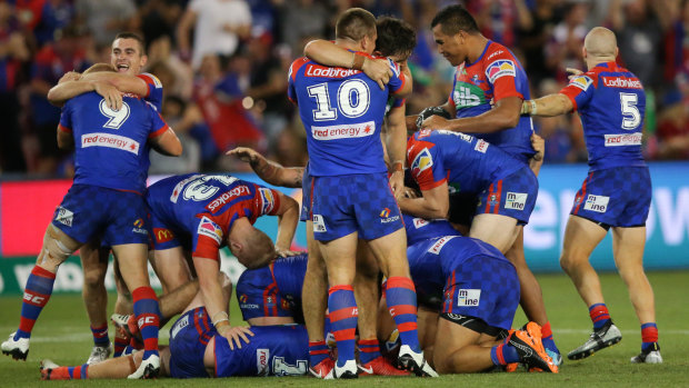 Local heroes: Jubilant Knights players mob Mitchell Pearce.