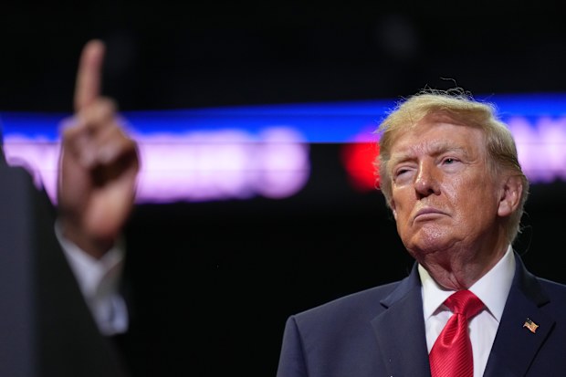 Donald Trump listens as gubernatorial candidate Vivek Ramaswamy speaks at a campaign rally earlier this month.