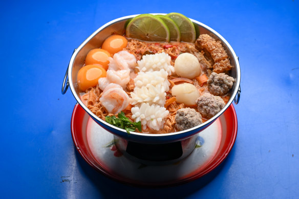 Ultimate bowl with prawns, scallops, calamari, crispy pork, instant noodles and egg yolk at Soi 38 in Melbourne.