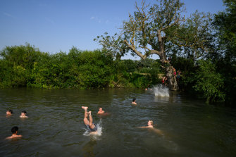 A man leaps into the River Cam in Cambridge as the temperature continues to rise.