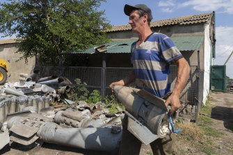 Bir çiftçi, Dnipropetrovsk bölgesindeki cephe hattından on kilometre uzakta tarlasında bulduğu Rus roketlerinin parçalarını topluyor.
