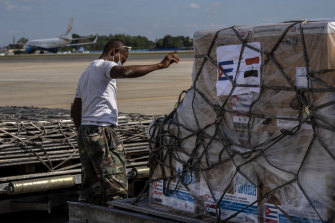 A ground crew member directs the loading of a shipment of Cuba’s homegrown COVID-19 vaccines donated to Syria, on the tarmac of the Jose Marti International Airport, in Havana.
