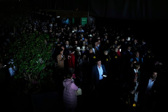 The spectators wander around the place of the Madrid Open Tennis Championship during a general blackout.