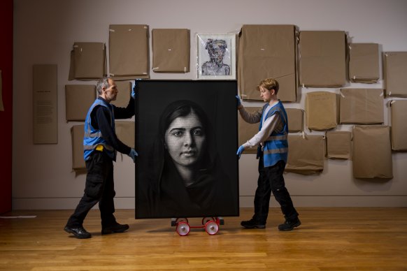 Gallery workers move Malala Yousafzai, 2018 by Shirin Neshat. 