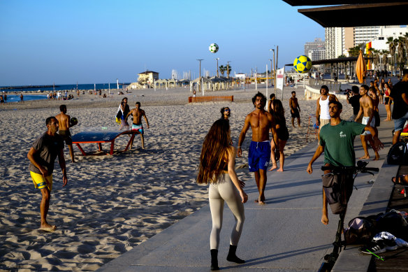 People play games on the beach last week in Tel Aviv, Israel. Despite the conflict, the Federal Government’s Smartraveller website only advises travellers to “reconsider” travelling to the country.